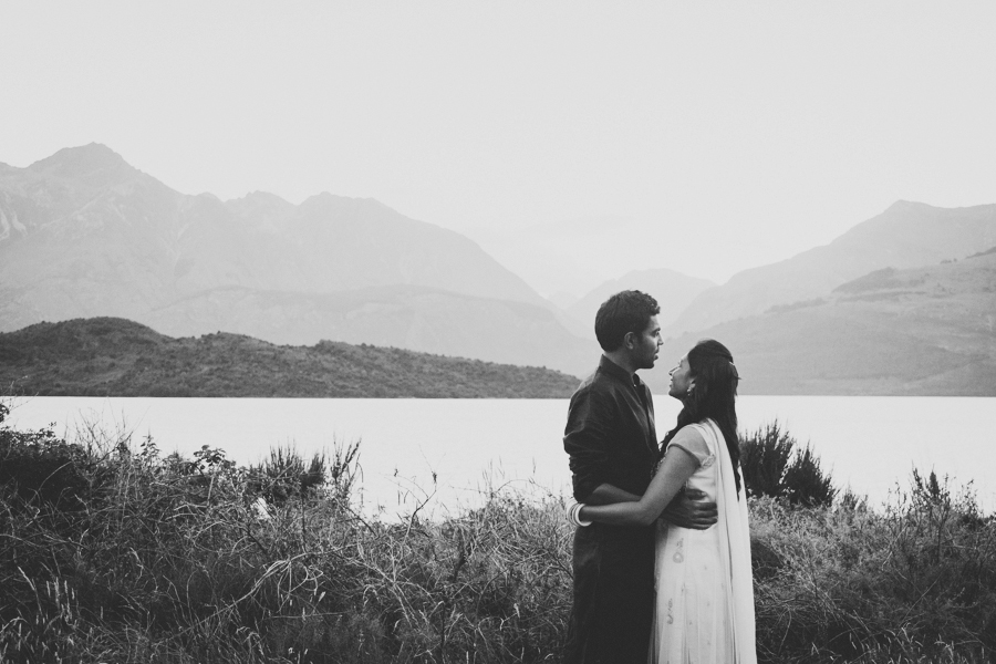 black and white of couple embracing in front of lake whakatipu
