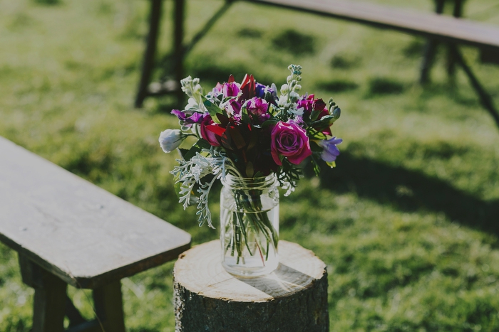 Detail, flowers in jars on them at outdoor wedding ceremony Mt Aspiring National Park, New Zealand