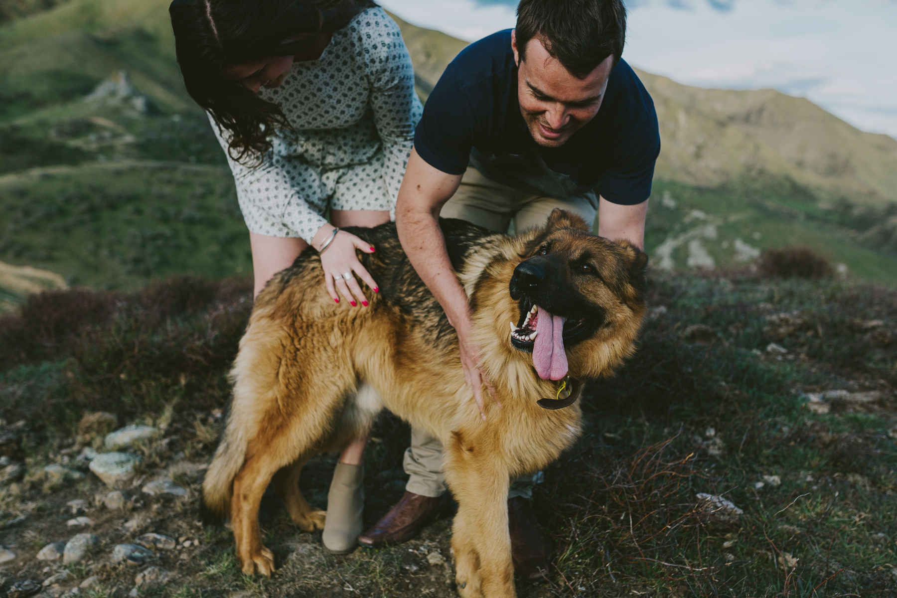 couple cuddling their dog on a mountaintop kurow