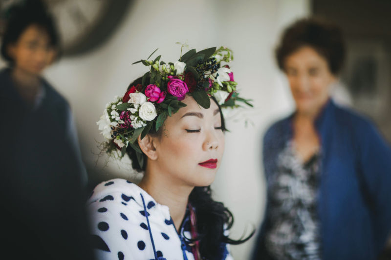bride in flower crown having make up done