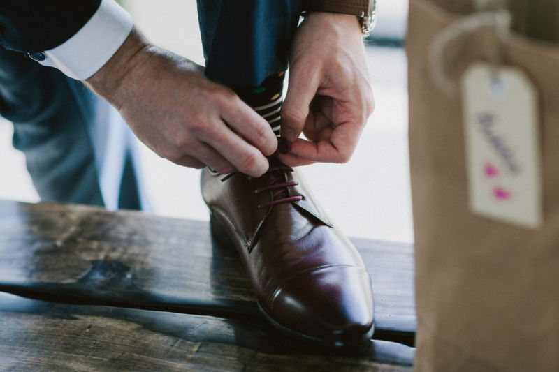 close up of groom doing up shoe