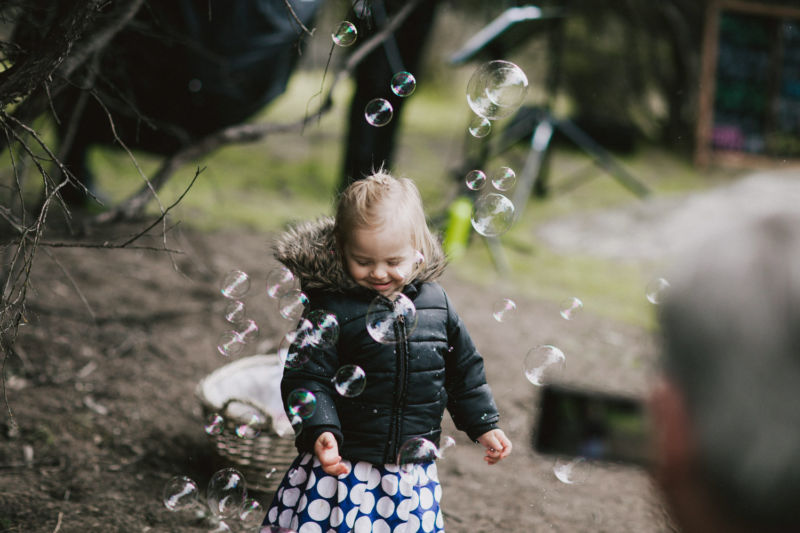 cute little girl playing with bubbles