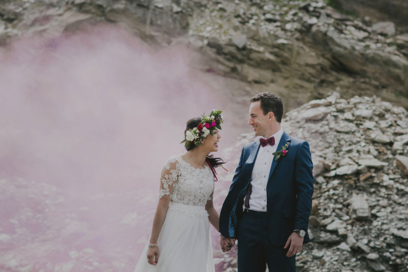 close up of bride and groom surrounded by pink smoke