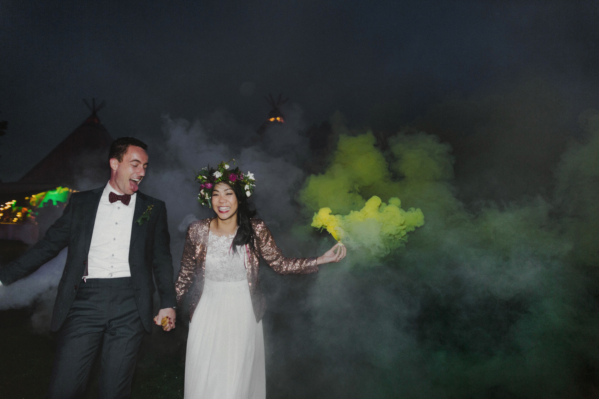 bride and groom running with smoke bombs in the dark