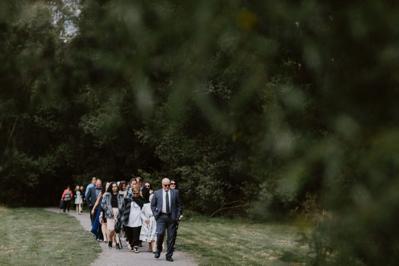 guests arriving in a line through the forest
