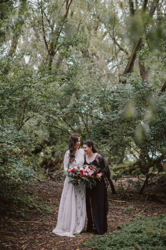 brides laughing together in forest