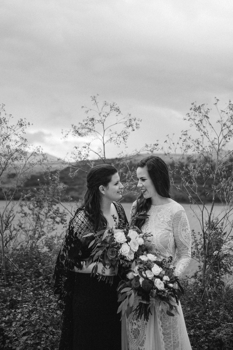b&w portrait of brides with lake behind 