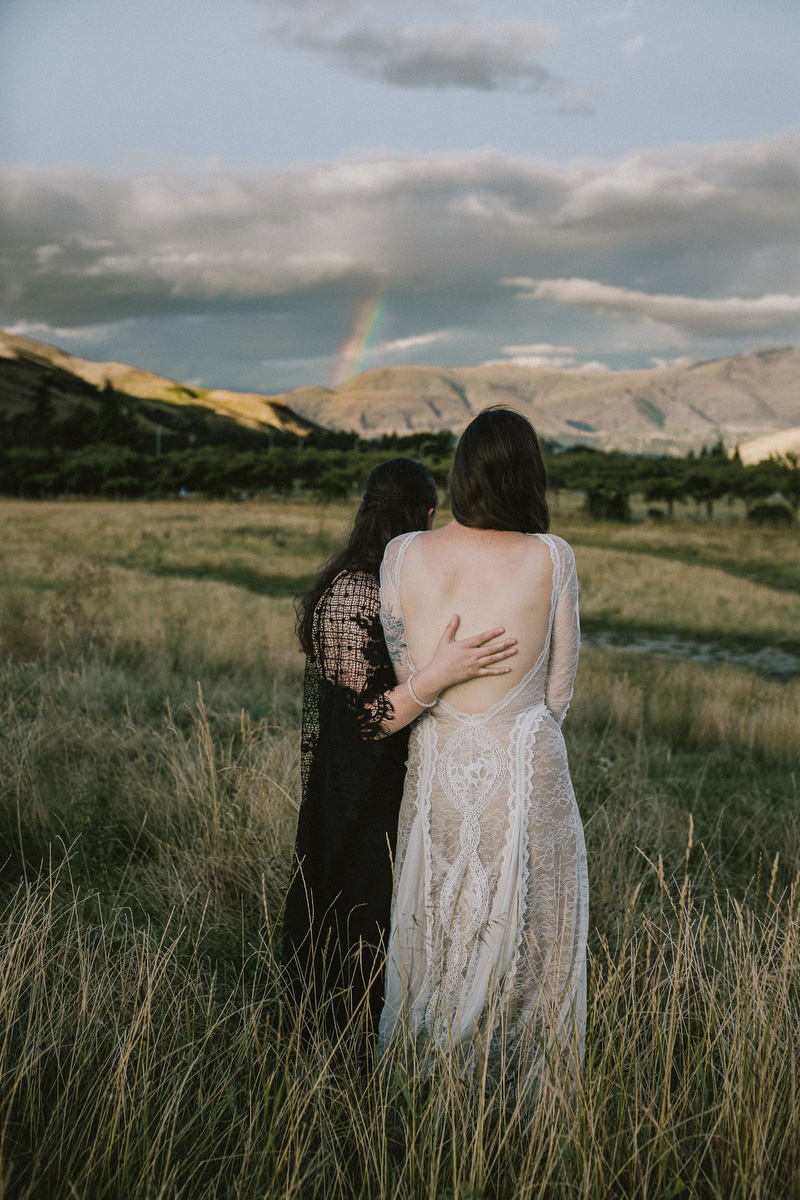 brides embracing and watching rainbow!