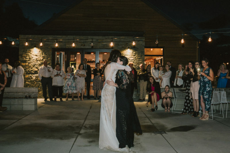 brides sharing first dance with each other and crowd looking on