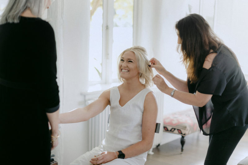 bride smiling while getting hair done