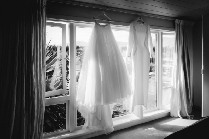 b&w of brides dress hanging in the window