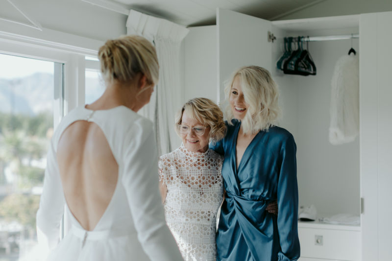 brides mother and sister admiring her dress