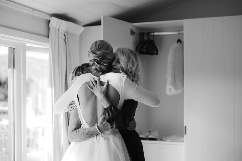 bride, sister and mother hugging
