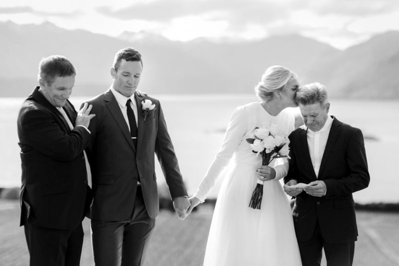 b&w ceremony moment with bride and groom and fathers