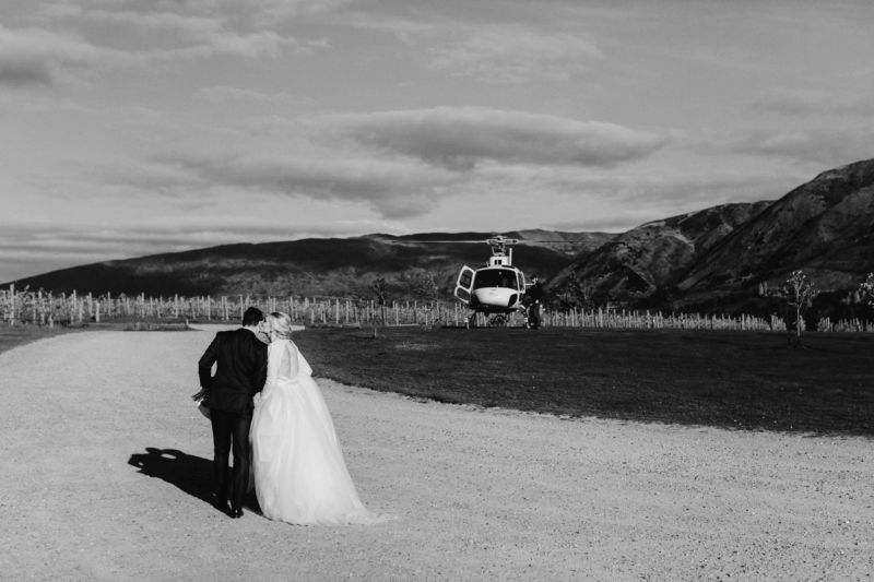bride and groom stopping for a kiss on way to helicopter