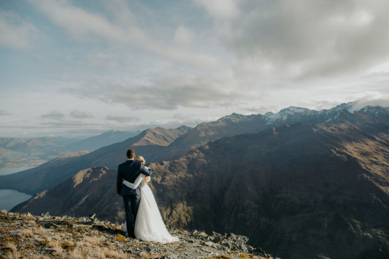 bride and groom on mountaintop hugging from behind