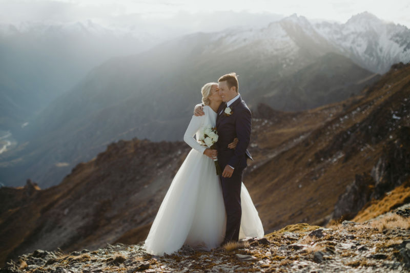 bride and groom on mountaintop hugging from front
