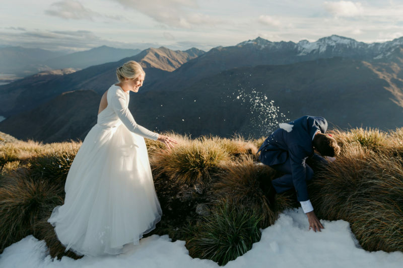 bride and groom on mountaintop bride hitting groom with snowball