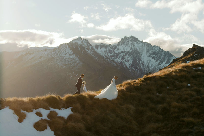 bride and groom on mountaintop walking on ridge