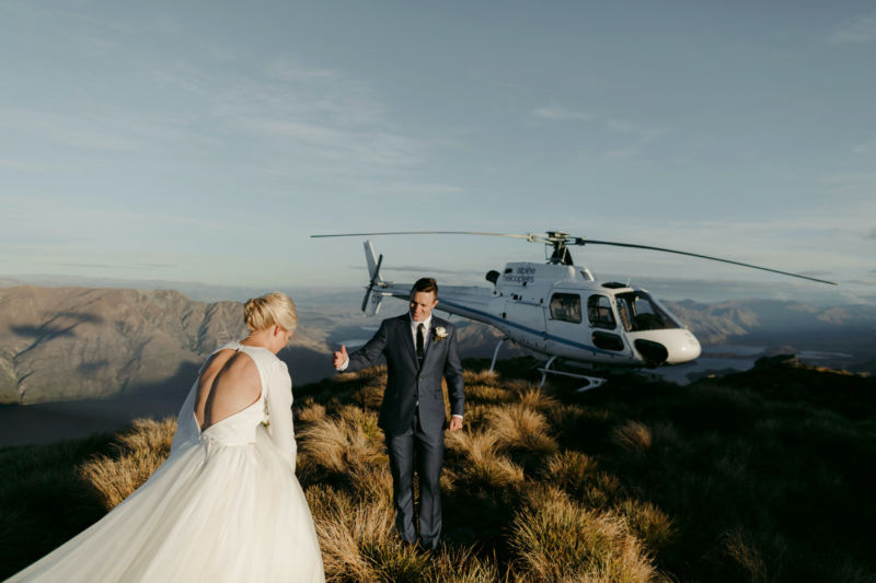 bride and groom heading towards helicopter