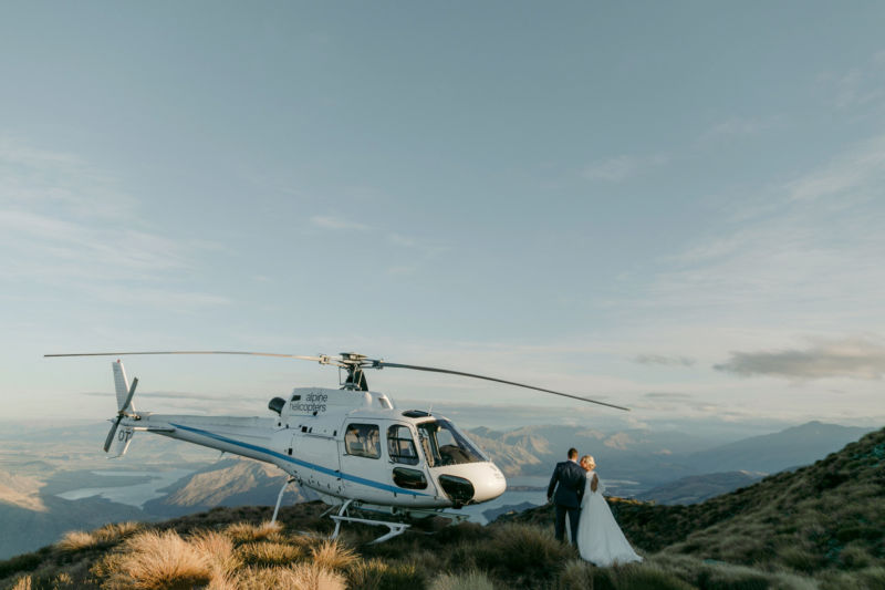 bride and groom pausing to kiss on way to helicopter