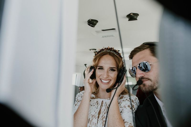bride and groom in helicopter with head sets on