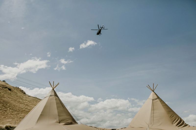 helicopter flying over tipis