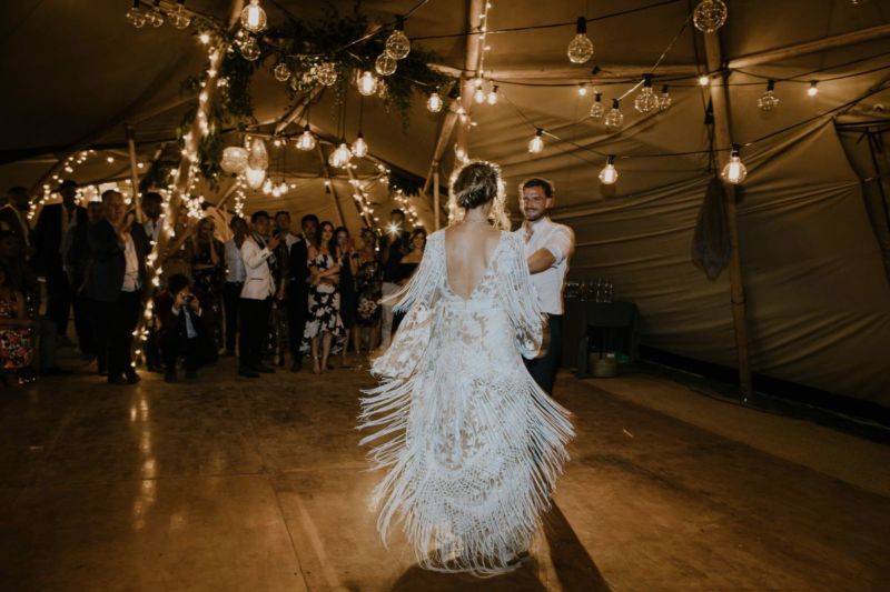 bride swinging dress on tipi dancefloor with back light