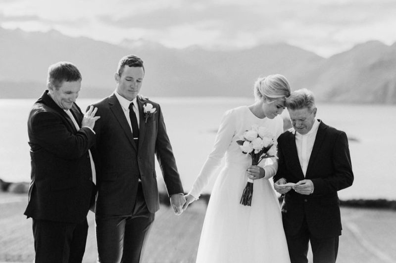touching ceremony moment between bride and groom and their dads in wanaka