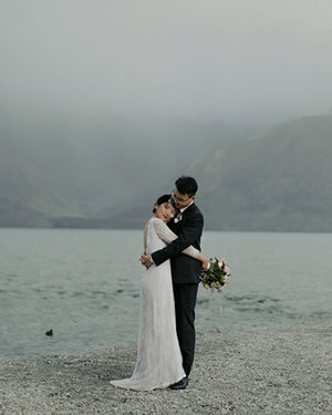 couple embracing beside the lake while a storm rolls in