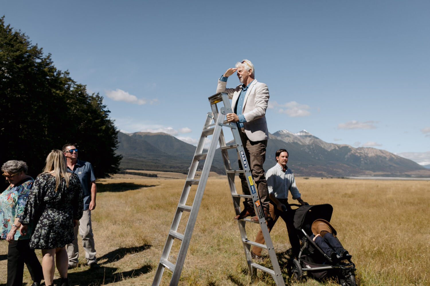 Guest up a ladder directing photo