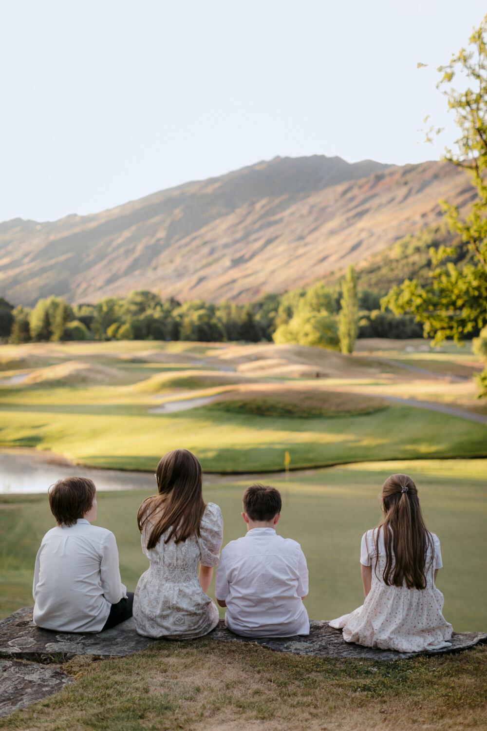 Candid of cousins sitting together overlooking the golf course at the reception at Millbrook Summer Wedding Queenstown