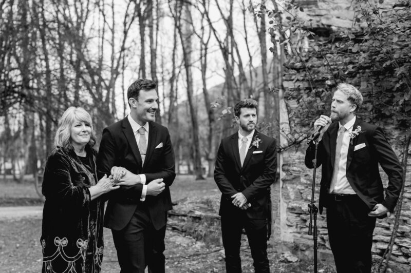 Groom and his mum arrive at ceremony while groomsmen sings