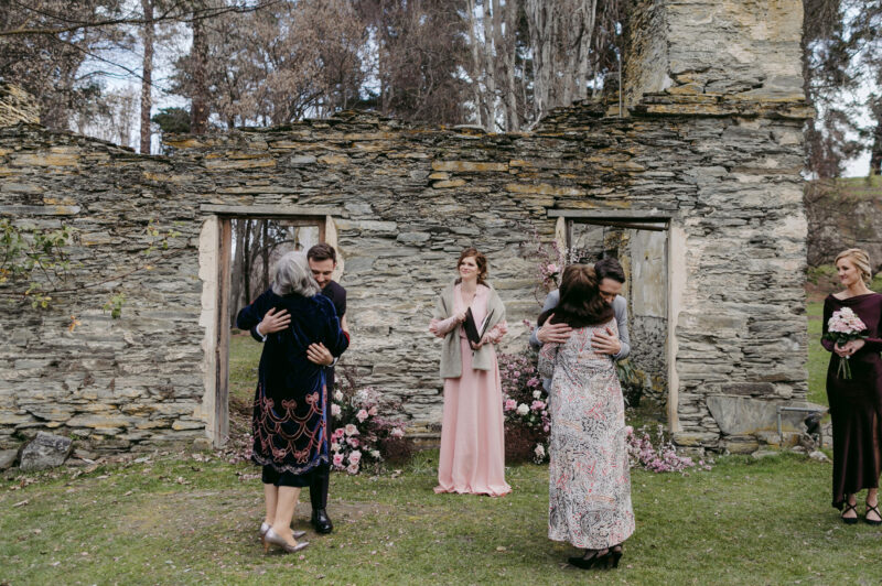 Both Grooms hug their mums