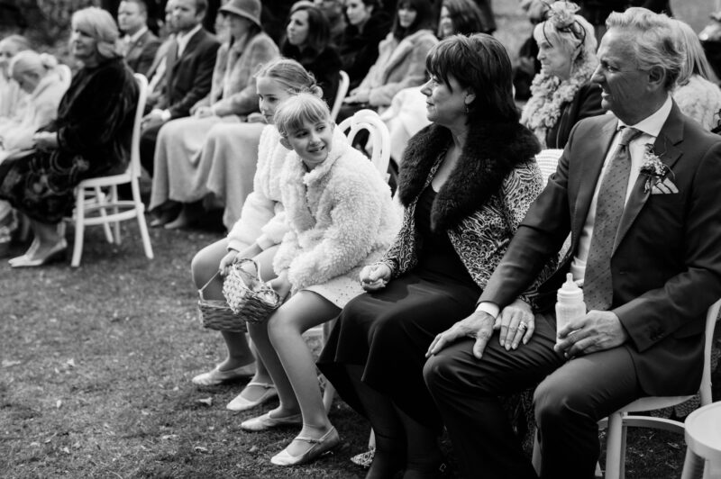 Candid of flowergirls delight, seated with guests