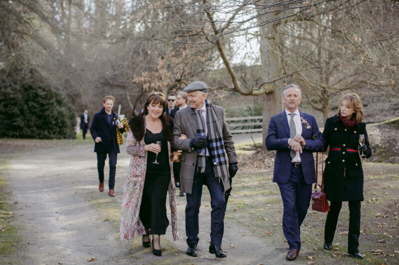 Grooms mum walking with guests through the gardens