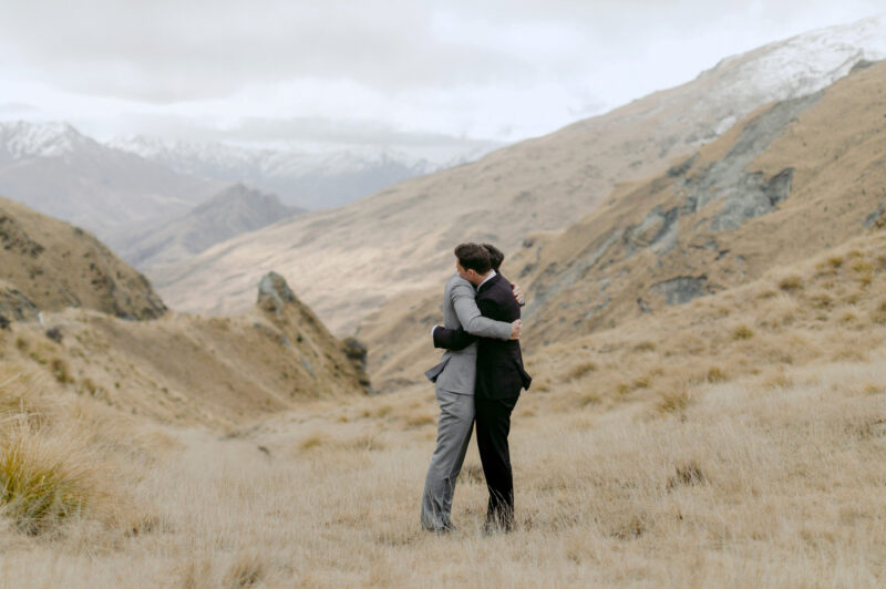 Liam and Steve portrait at Skippers canyon wider shot of hug showing valley