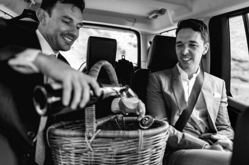 Liam and Steve back in car pouring a drink