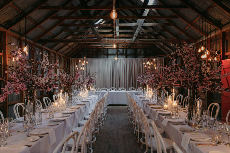 Close up of Liam and Steves Reception venue with tables, candles and flowers wide shot