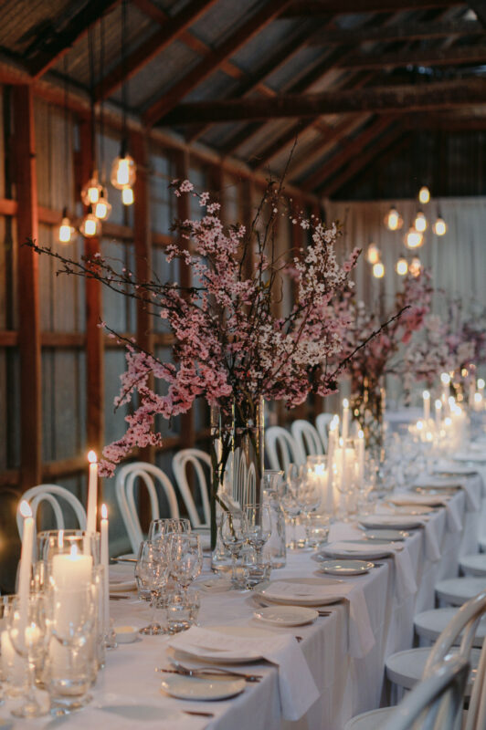 Close up of Liam and Steves Reception venue with tables, candles and flowers blossoms and lights