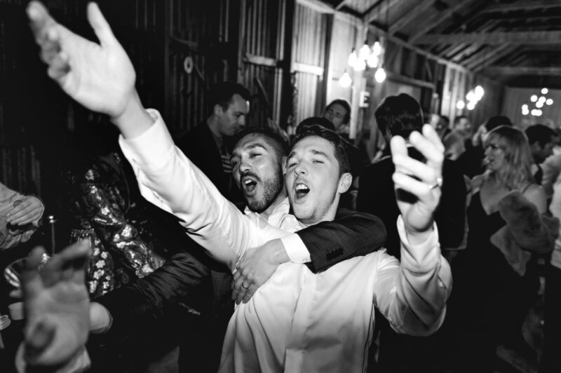 End of the night on the dancefloor, arms held high in fun times b&w