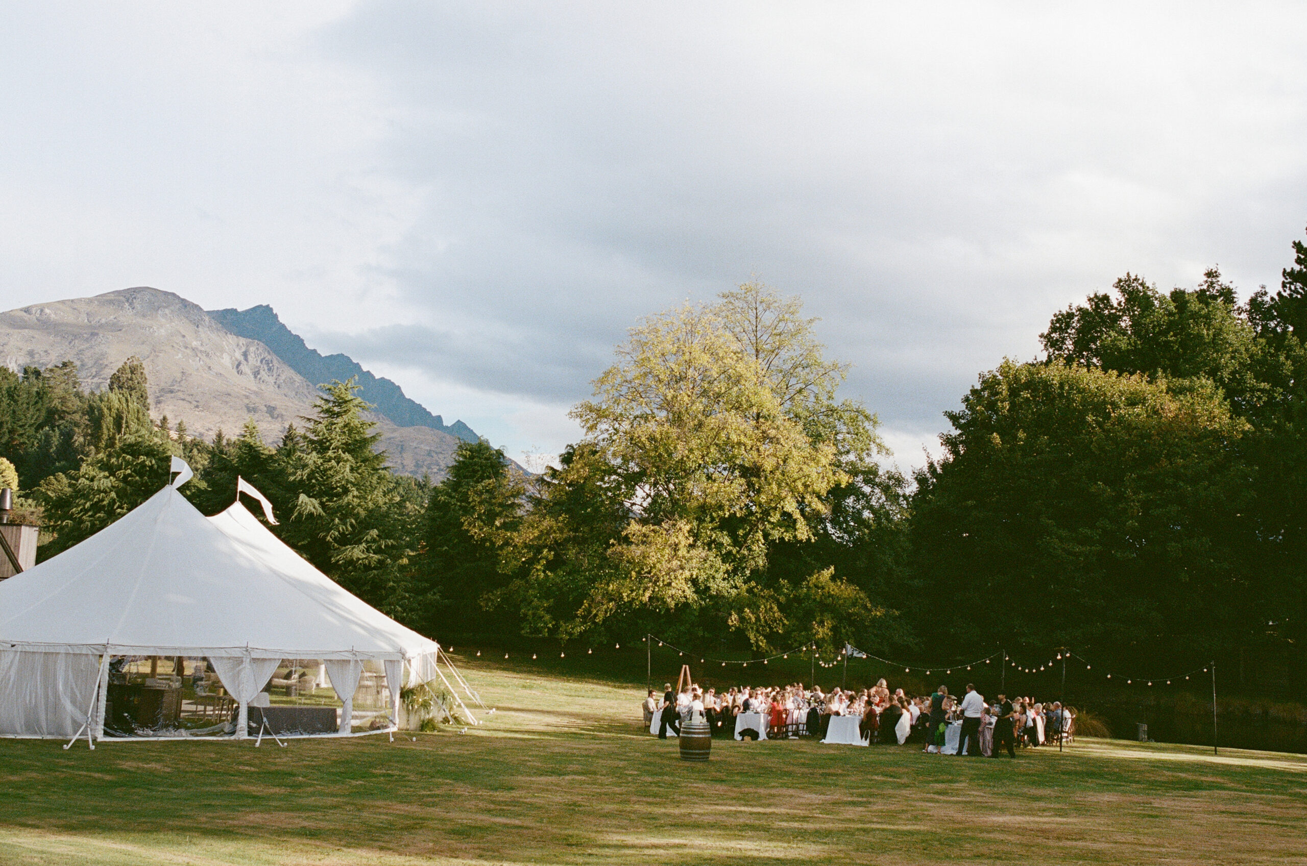 wide shot of the reception with views of the tent, the outdoor seating and mountains in the background
