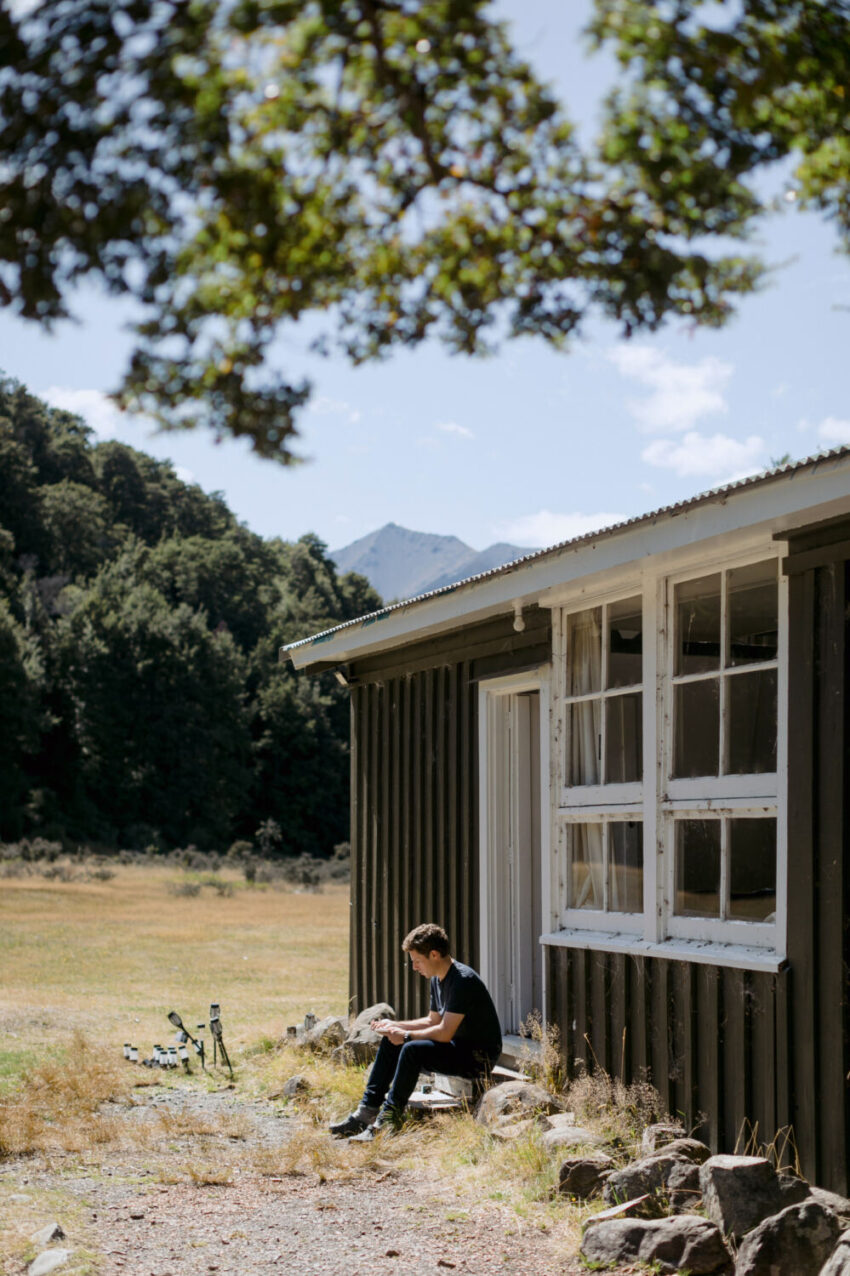 Man sitting next to hut