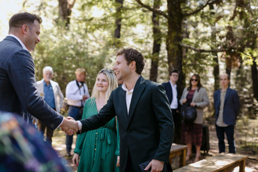 Groom shaking hands with guest