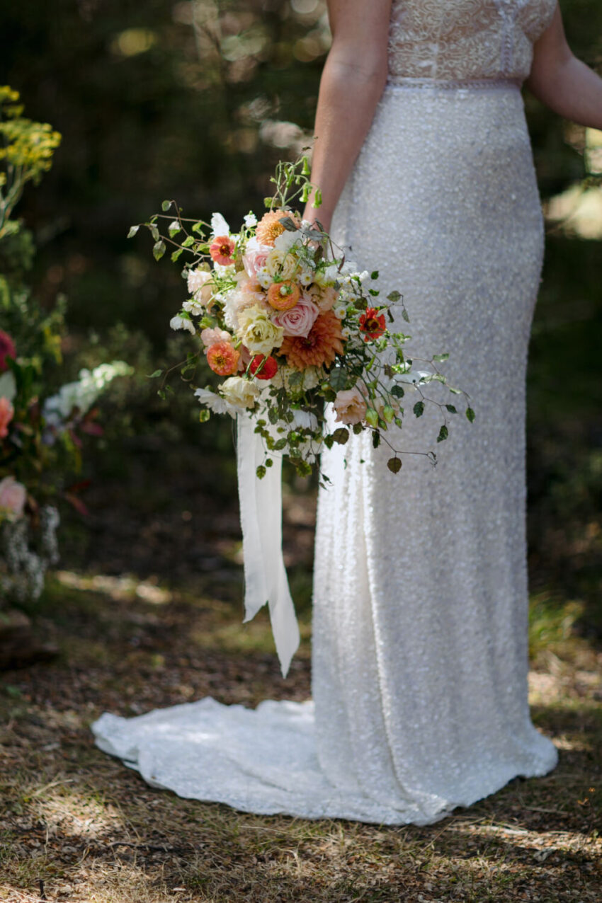 Close up of brides dress and flowers during ceremony