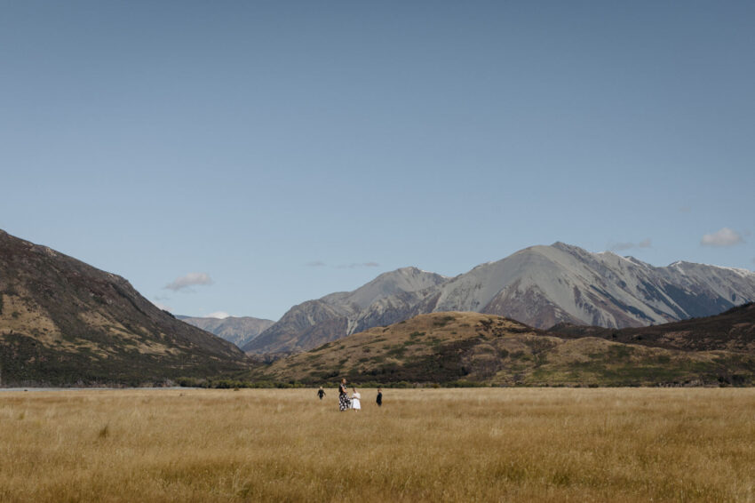 Guests with kids running in sunny field