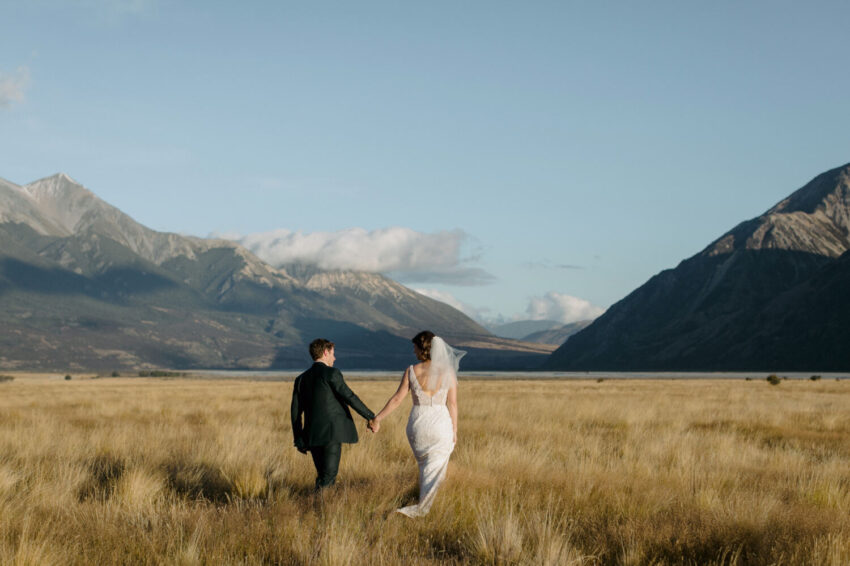 Bride and Groom walking into golden light landscape