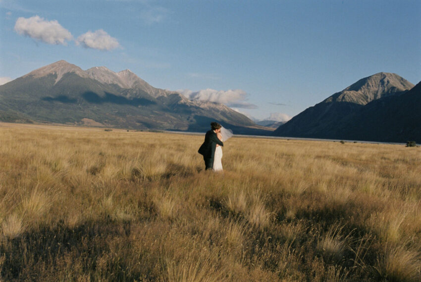 Bride and Groom embracing in landscape