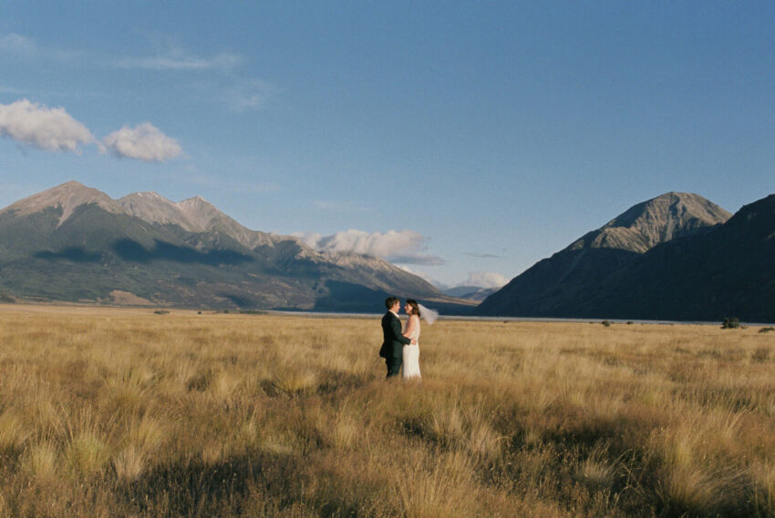 Bride and Groom embracing in landscape