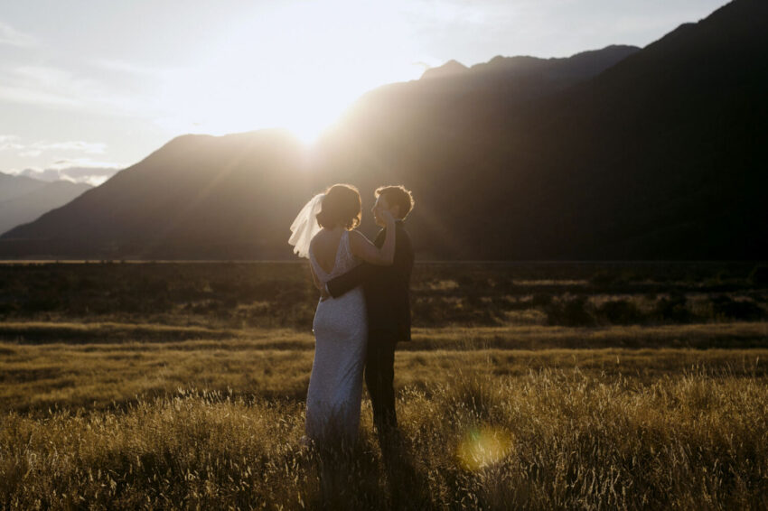 Bride and Groom hugging in sunset